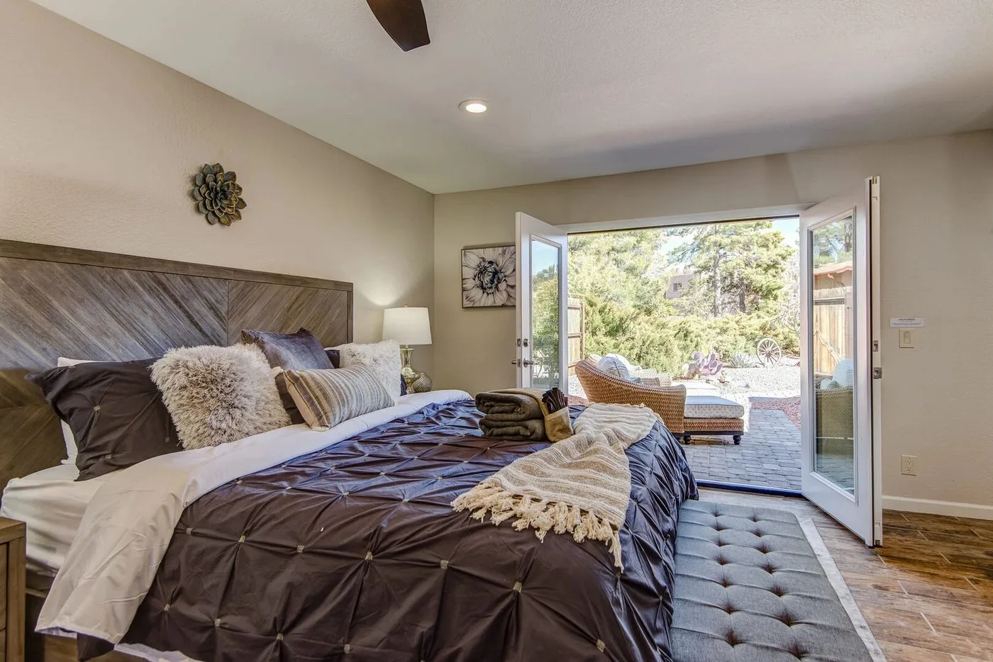 Styled Sedona primary bedroom with king bed and French doors opening to the patio